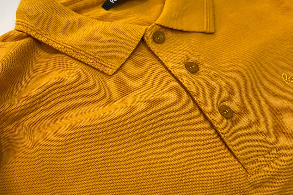 closeup of orange color polo shirt with three buttons on front